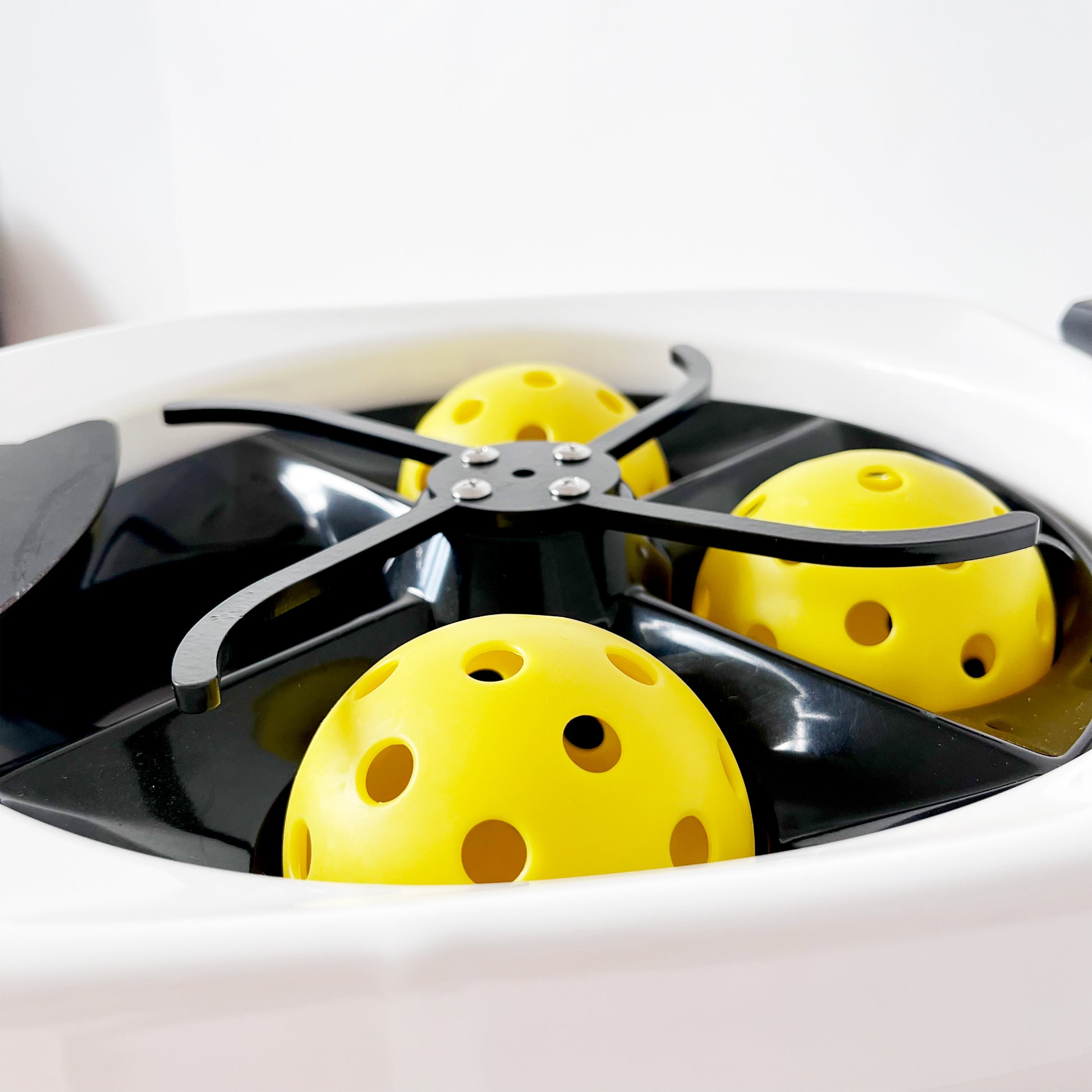 Jbotsports Pickleball Machine JP-L6 - Ball Feeding Mechanism with Yellow Pickleballs Inside the Hopper for Automatic Training